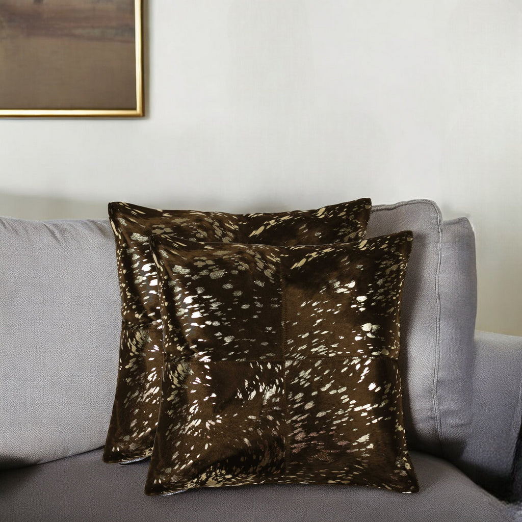 Brown patterned pillow on a gray sofa with a neutral wall background