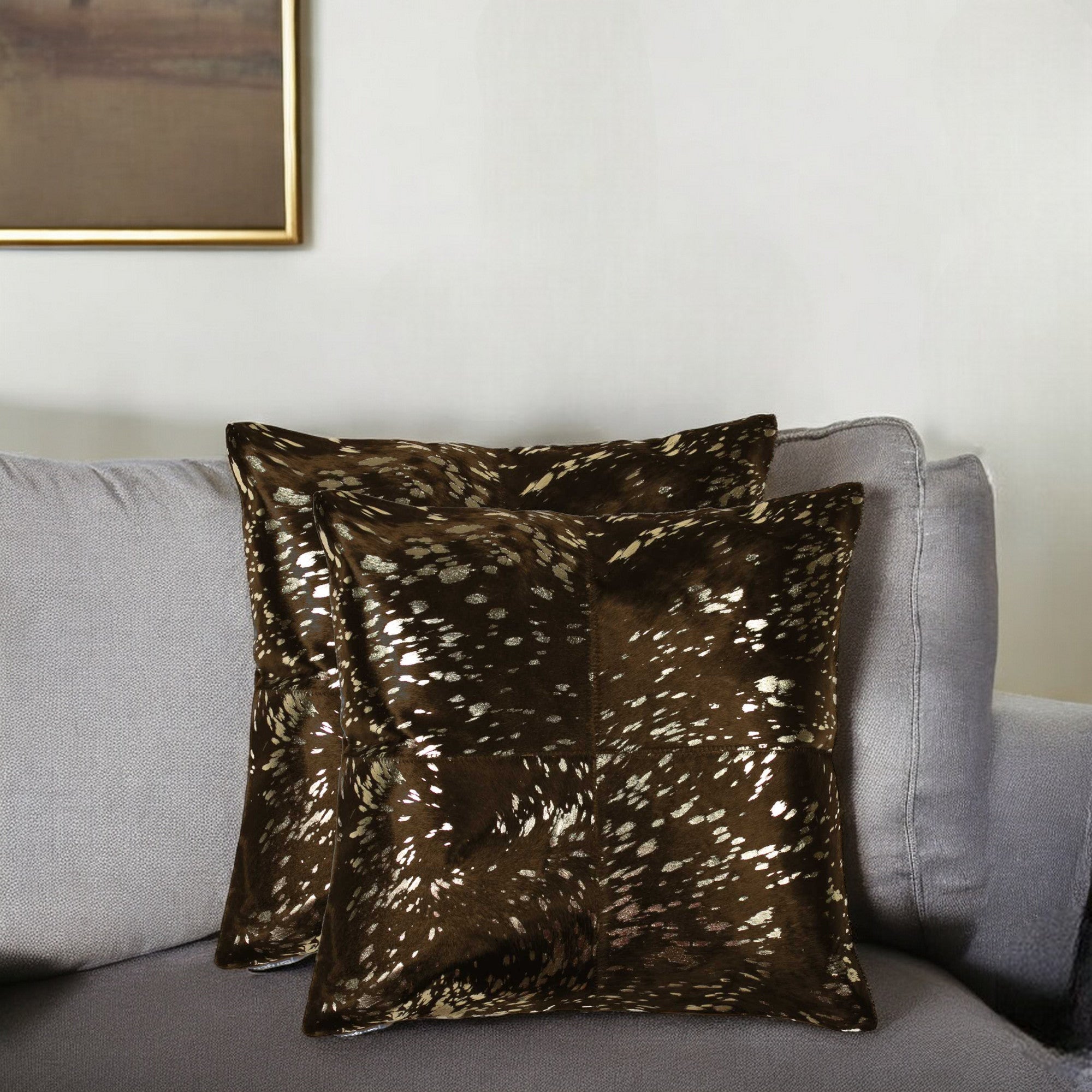 Brown patterned pillow on a gray sofa with a neutral wall background