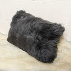 Gray fluffy pillow on a textured surface