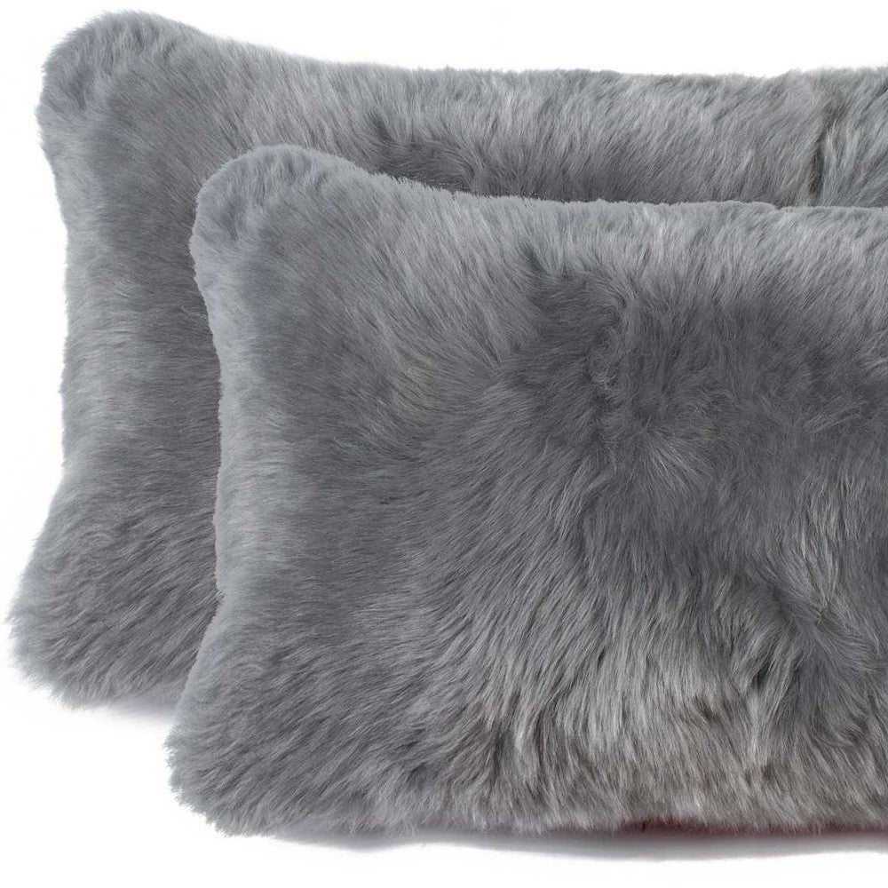 Two gray fluffy pillows on a white background