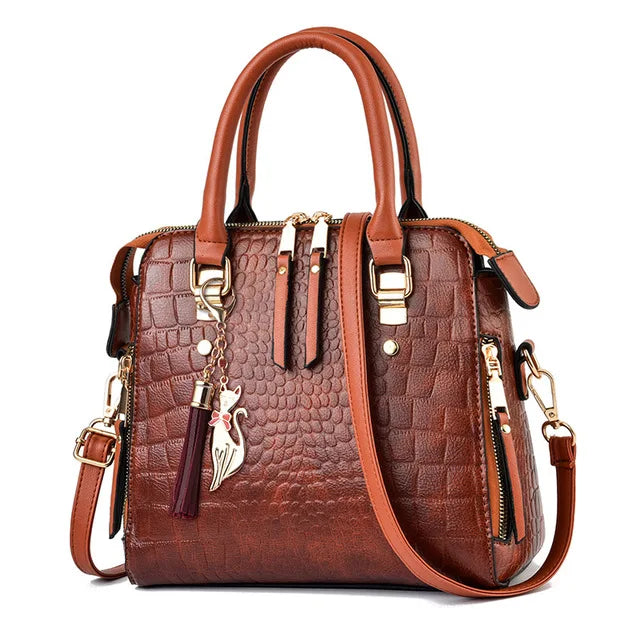Brown textured handbag with gold accents on a white background