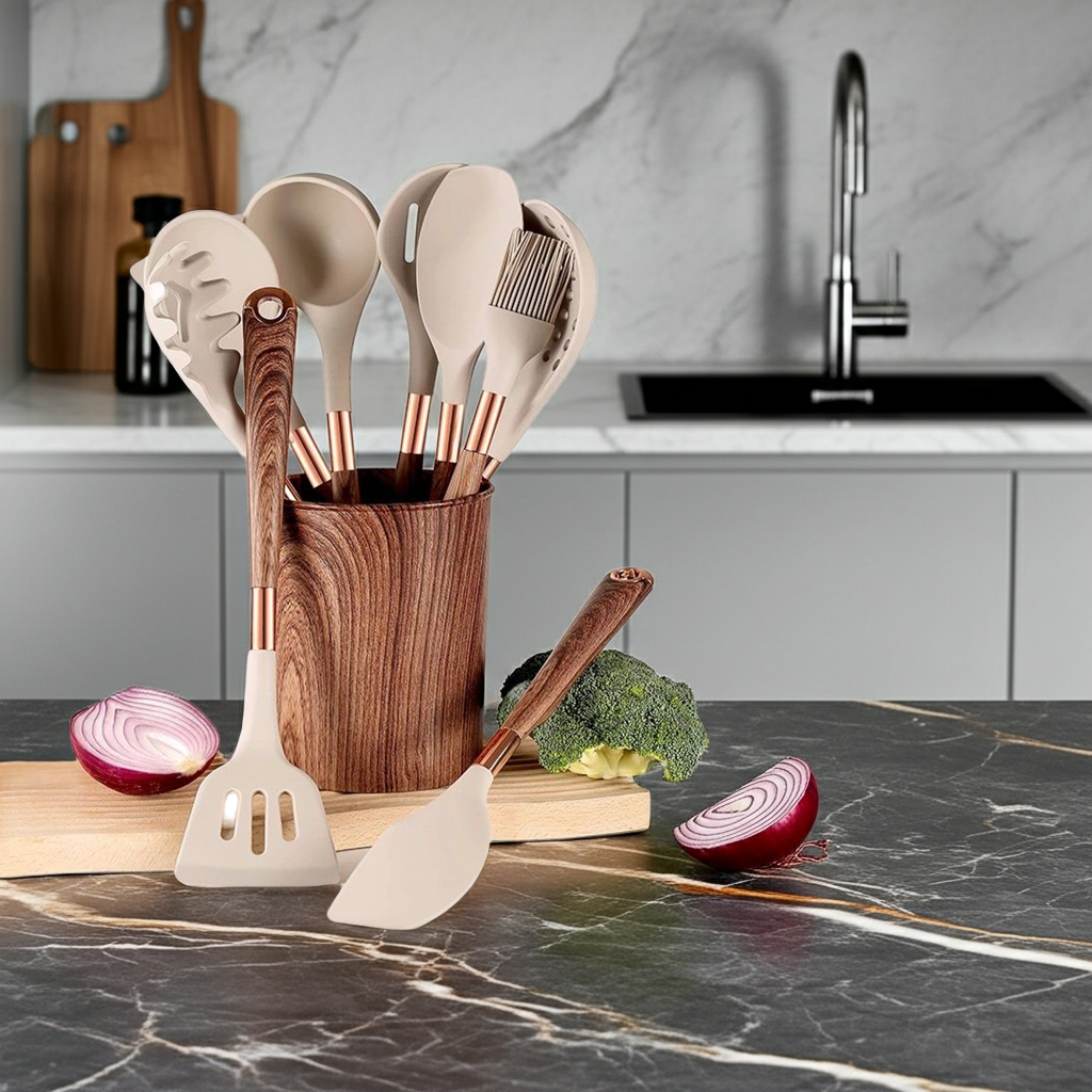 Wooden utensil holder with kitchen utensils on a marble countertop